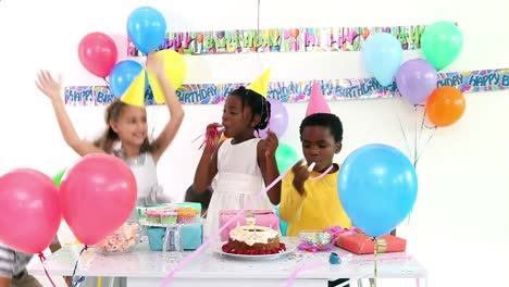 Animation-of-red-shapes-over-diverse-happy-children-with-balloons-having-fun-at-party,-on-white