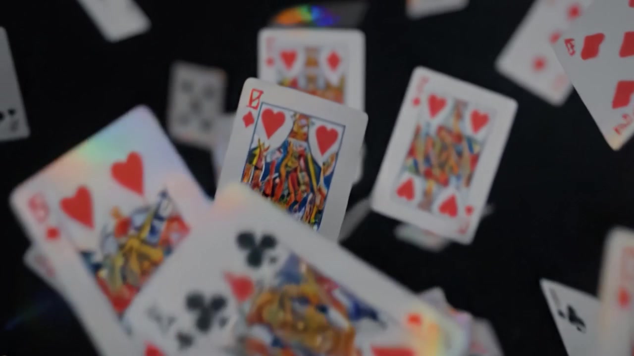 Uno Spettacolo Affascinante di Carte da Gioco che Cadono in uno Spazio Oscurato, Mostrando il Movimento Dinamico e i Design Eleganti di Ogni Carta Mentre Scendono a Cascata