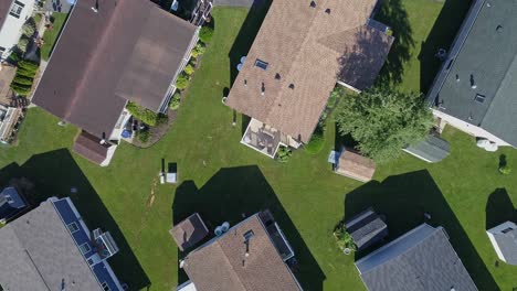 an aerial down looking view of a well kept mobile, manufactured, prefab home park of single wide and double wide houses on a sunny day