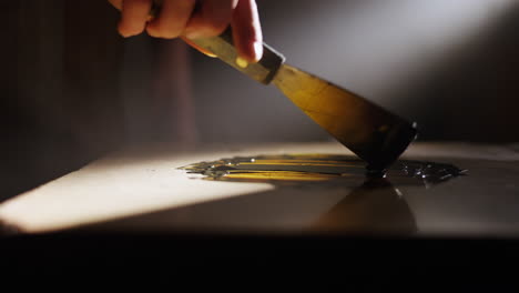 artist using palette knife to mix paint