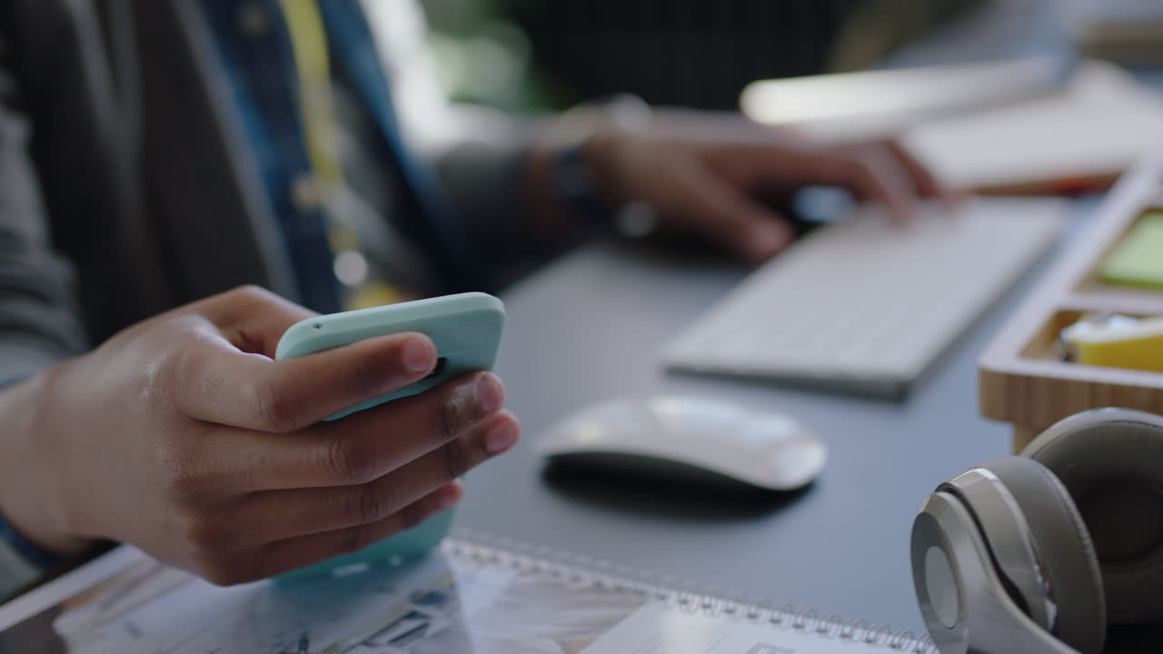 happy african american business man checking smartphone reading corporate documents brainstorming ideas using computer planning strategy successful career in modern startup communication company
