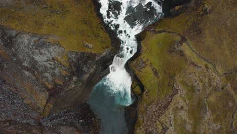 drone shot flying over a large waterfall with the camera tilting up in iceland 4k