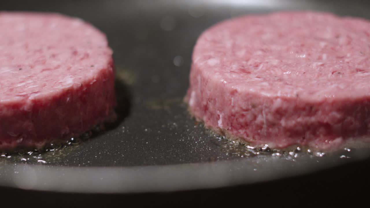 Raw Pink Beef Burgers Starting to Cook in Hot Pan. British Meat Minced and Made into Cutlets. Tasty Fresh Food