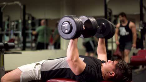 Closeup-side-shot-of-bodybuilder-doing-dumbbell-bench-presses