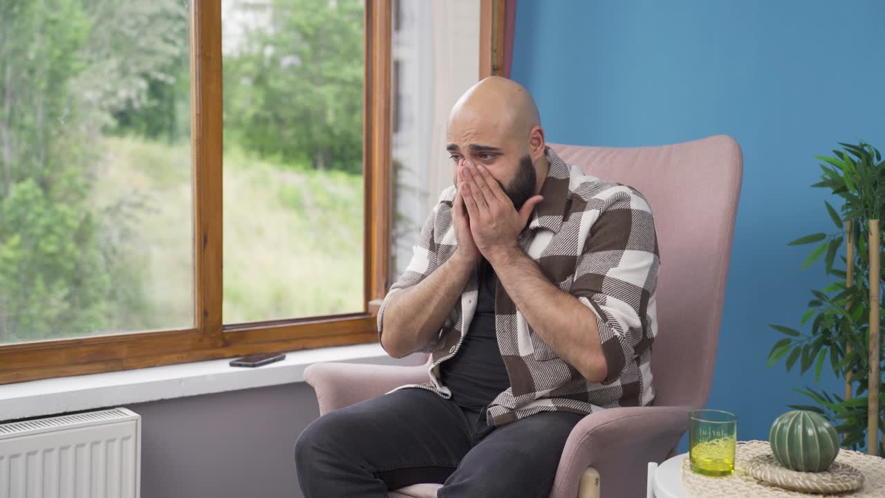 Uomo che non sta bene guarda fuori dalla finestra per rilassarsi.
