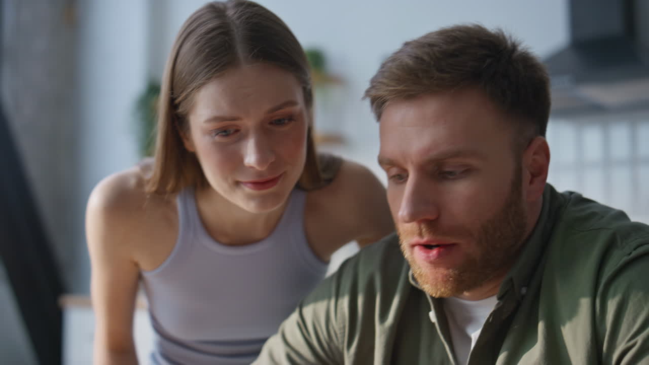 Woman supporting overloaded husband typing on laptop at home office closeup
