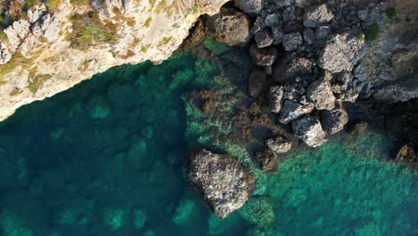 emerald sea water on rocky shore of a stunning ionian peninsula in albania, captured by ascending drone