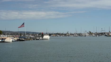 View of American flag as it waves across Balboa Bay, view is southwest. Bright sunny day.