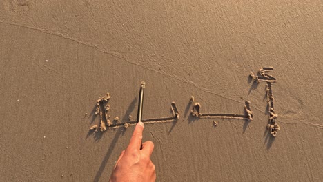 “alif baa” written by hand on beach sand,enjoying outdoor summer activities