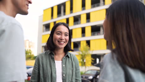 Group-Of-Three-Happy-Young-Japanese-Friends-Standing-Outdoors-And-Talking-To-Each-Other-3