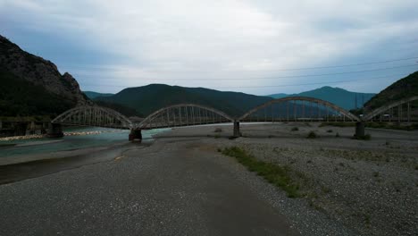 Bewahrung-Der-Vergangenheit-Der-Historischen-Brückenbögen-über-Dem-Mat-River,-Der-An-Trüben-Tagen-Durch-Erosion-Und-Unregulierte-Sandausbeutung-Gefährdet-Ist