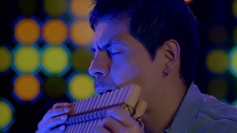 close up shot of musician playing pan flute instrument from andes of peru and bolivia