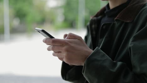 cropped shot of woman using mobile phone outdoor