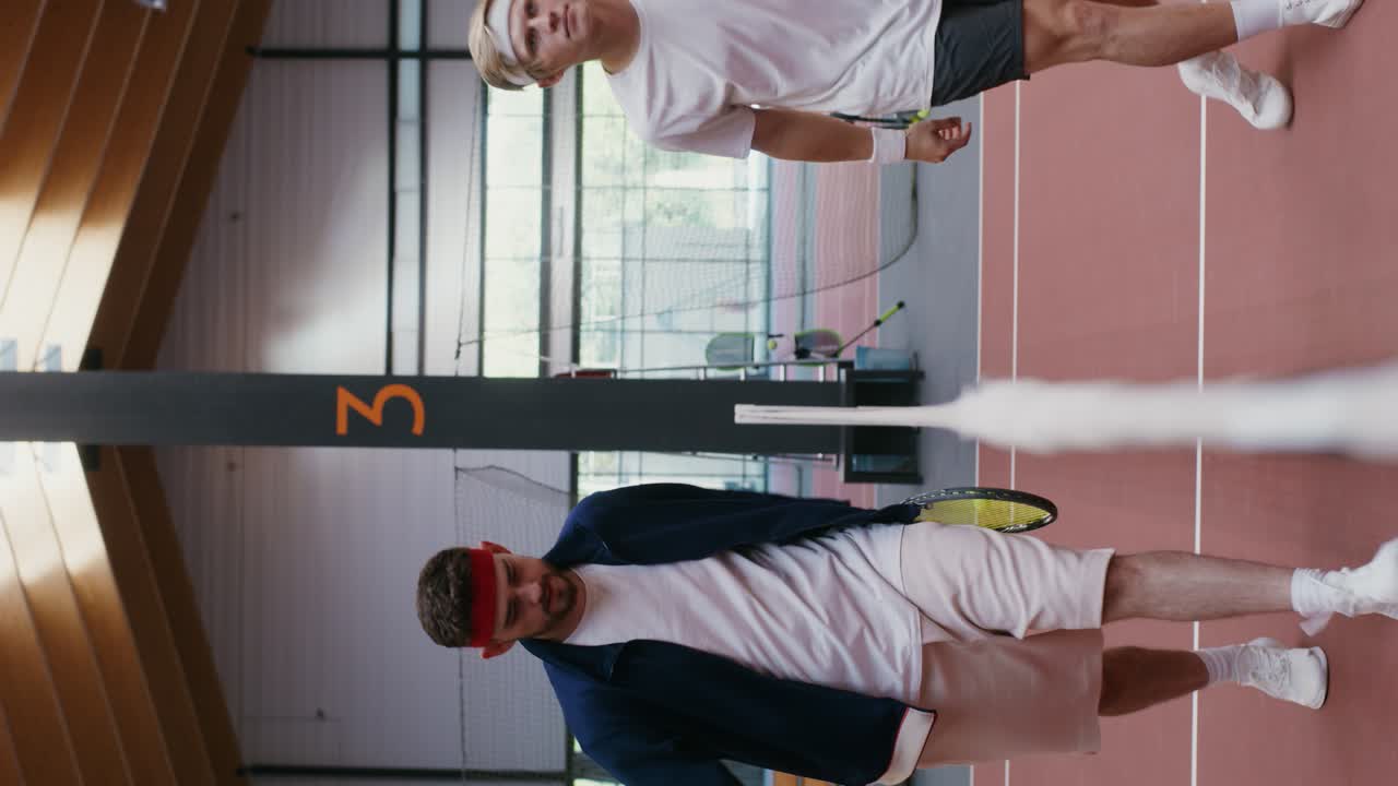 To mænd spiller tennis indendørs