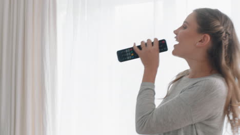 mujer feliz cantando karaoke en casa divirtiéndose bailando a la música celebrando el éxito disfrutando de la danza divertida sintiéndose positiva estilo de vida logro 4k metraje