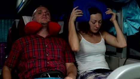 a man and a woman go to sleep in the bus