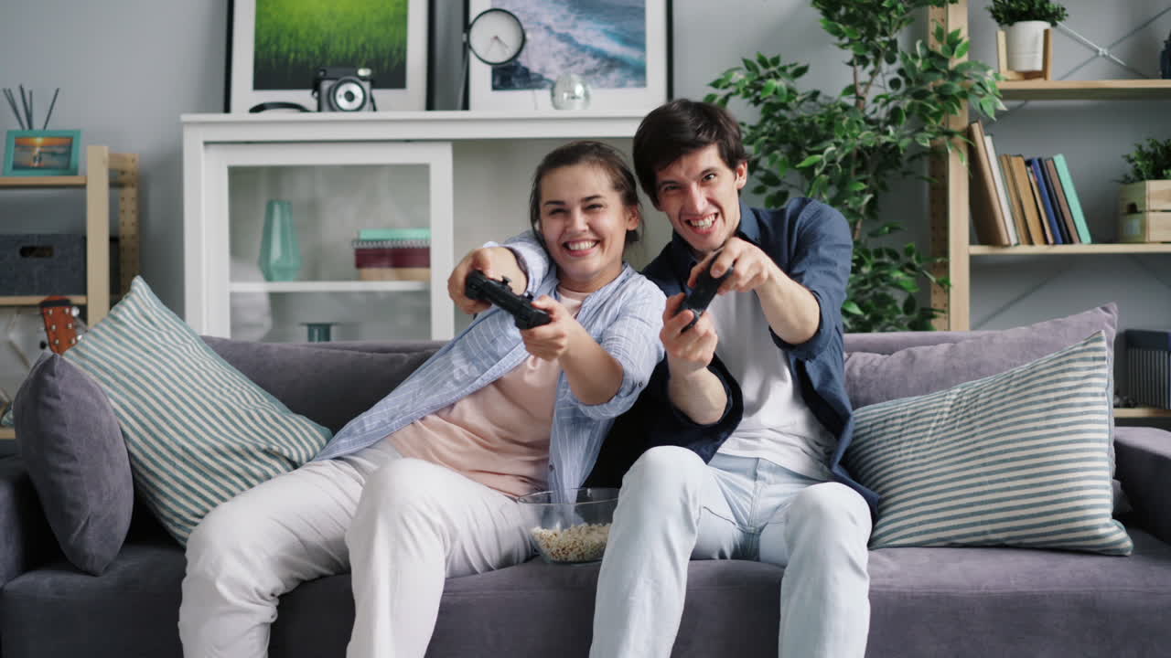부부 가 집 에서 비디오 게임 을 하고 있다