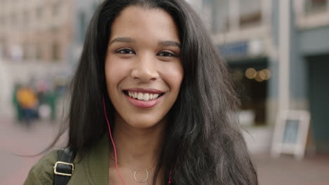 Retrato-De-Una-Joven-Y-Alegre-Mujer-De-Raza-Mixta-De-Vacaciones-Riendo-Feliz-Disfrutando-De-Viajar-Usando-Auriculares-Escuchando-Música