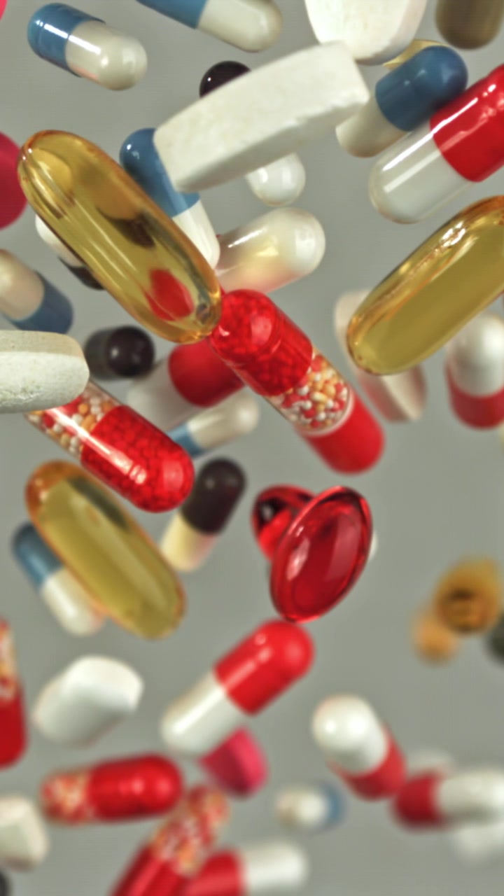 Multicolored Pharmaceutical Pills and Capsules Falling in Slow Motion