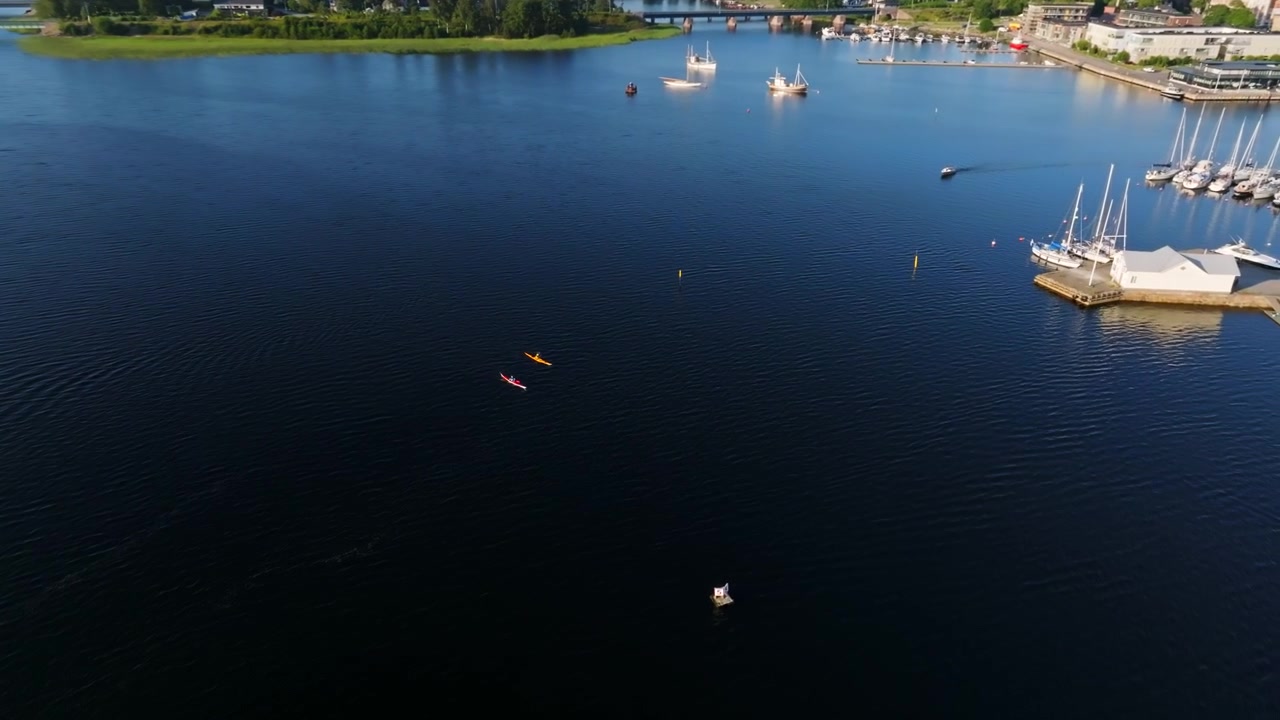 Drone shot around people kayaking in front of Tammisaari city, summer in Finland