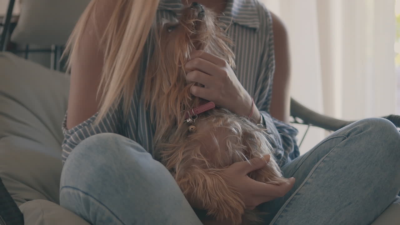 mujer acariciando a su perrito en casa
