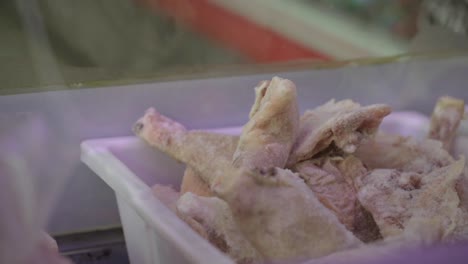 bandeja con patas de pollo crudas para la venta en la carnicería del supermercado