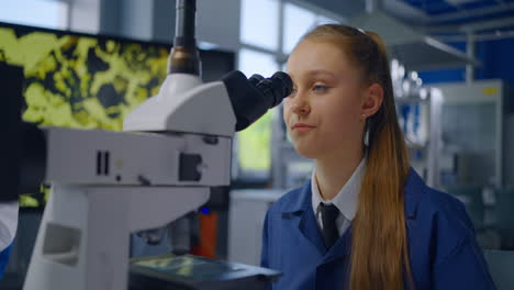 estudiante usando el microscopio en un laboratorio de ciencias