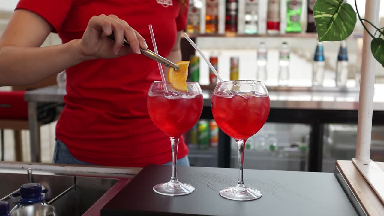 el camarero preparando cócteles rojos.