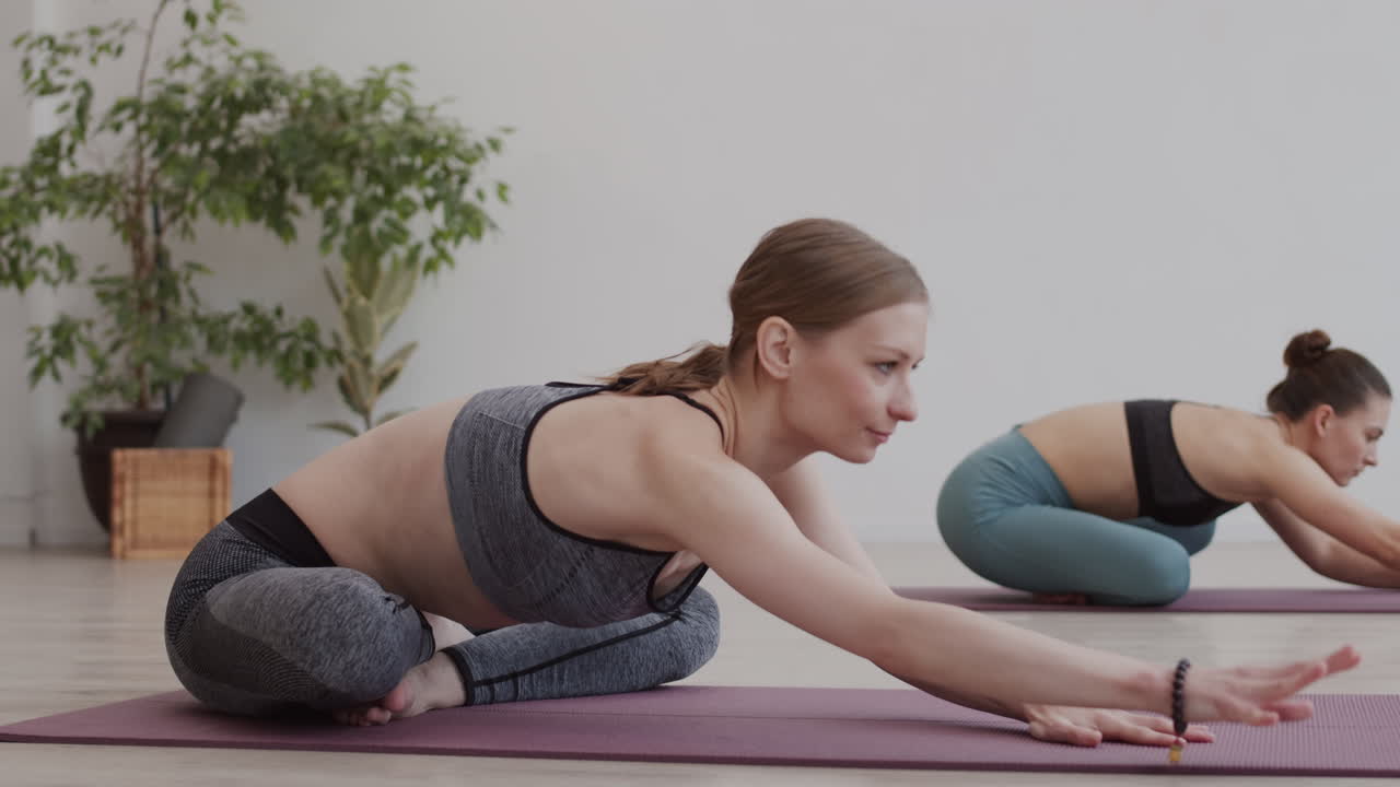 dos mujeres caucásicas deportivas haciendo entrenamiento de estiramiento.