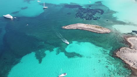 amazing drone aerial landscape of the charming beach es trencs and the boats with a turquoise sea. it has earned the reputation of caribbean beach of mallorca. spain