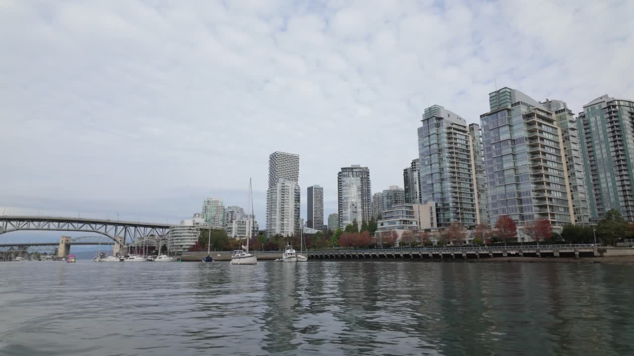 Gimbal shot from a moving boat of David Lam Park along False Creek during autumn in Vancouver, British Columbia, Canada. 4K