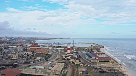 historical red and white rock lighthouse near accra, ghana