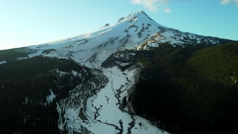 us, oregon, mt hood, white river, 2025-04-22 - drone view of mt hood at sunset over the white river in spring, with snow still covering the mountain and creek and trees