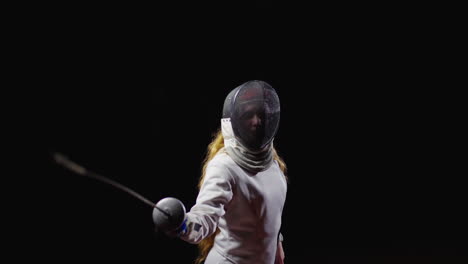 young woman fencer practicing with her sword