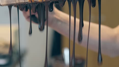 el confitero da la vuelta a la forma y golpea el chocolate