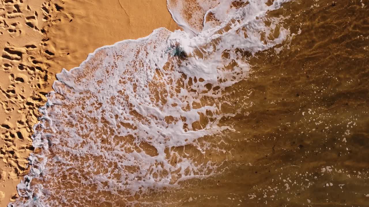 에리세이라 포르투갈, 모래에서 발자국을 지우는 멋진 파도의 샷