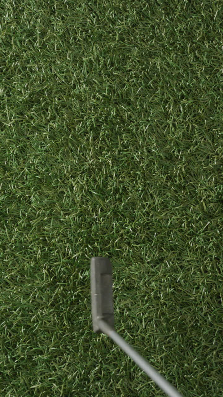 Vertical viedo of golf ball and club on grass, copy space, slow motion