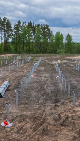 steel posts installed in cleared field during solar panel construction, vertical