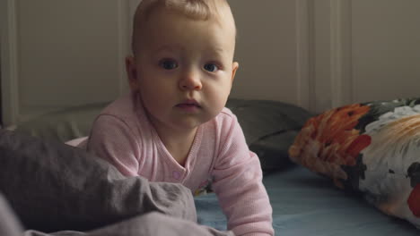 active smiling baby girl on the bed at home