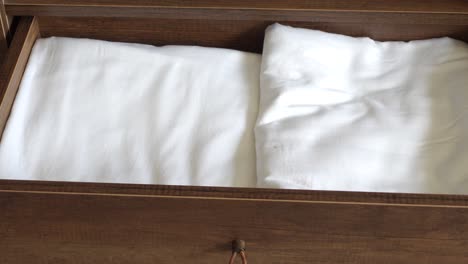 opened drawer with clean sheets and pillows