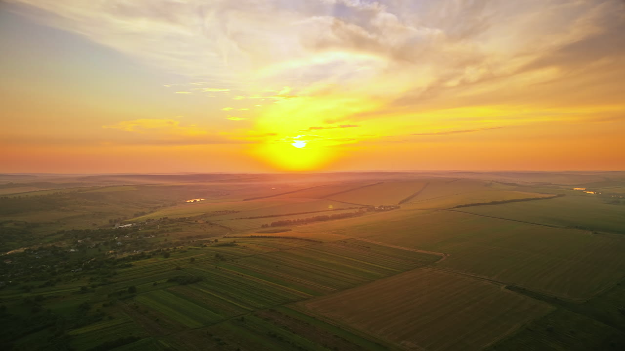 Aerial drone view of nature in Moldova at sunset. Village, sun, fields and hills