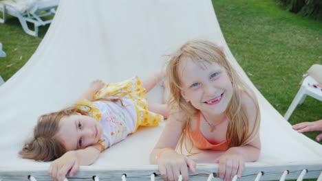 Two-Cool-Girls-Lie-On-A-Hammock-Laugh-And-Look-At-The-Camera-Top-View