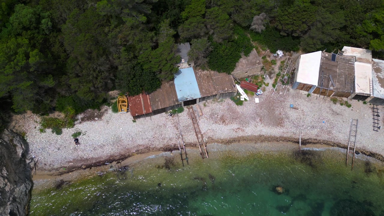 Cala Llentrisca, a secluded beach in Ibiza, highlighting the pristine turquoise waters and surrounding verdant landscape. Marvelous aerial view flight ascending drone
camera pointing down