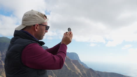 hiker looking at compass while hiking in the mountains