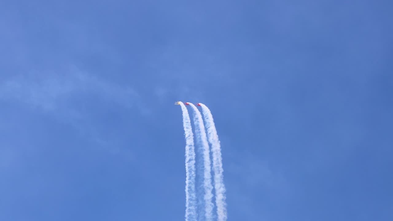 비행기 들 이 하늘 에서 연기 흔적 을 가지고 스턴트 를 수행 하고 있다