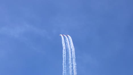 aviones realizando acrobacias con rastros de humo en el cielo