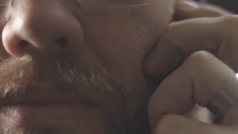 Static-Extreme-Closeup-Shot-Of-A-Man-Reluctant-To-Talk-On-Phone