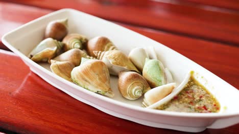 mariscos de conchas de alas hervidas con salsa de inmersión
