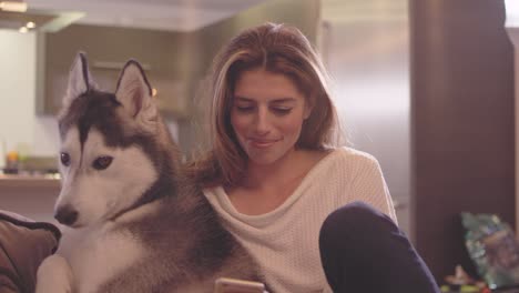 beautiful young woman relaxing in her living room with her adorable dog.