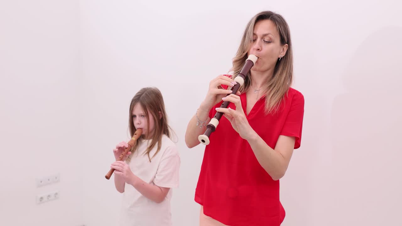 Woman and girl playing recorders